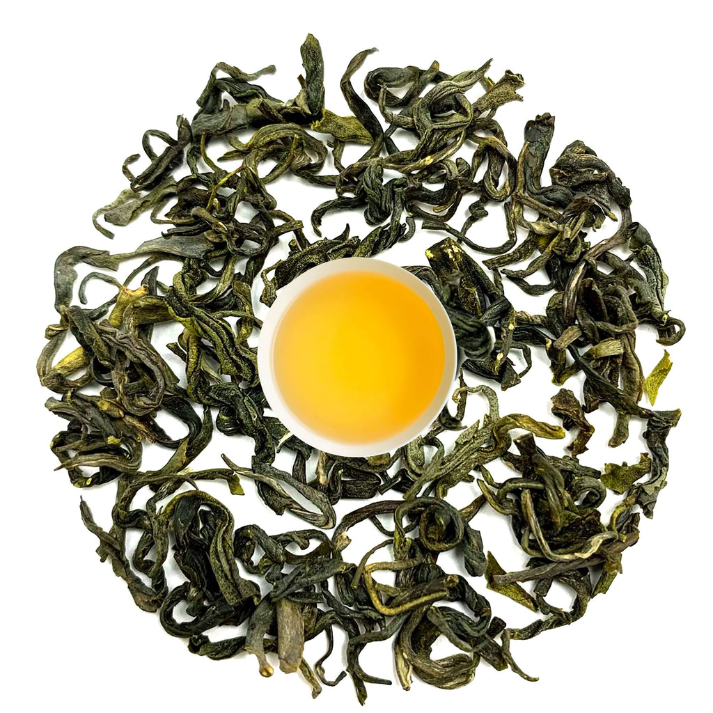 29 Nepal green tea leaves arranged around a cup of smooth, grassy tea, showcasing rich Himalayan flavor.
