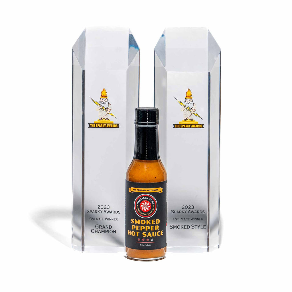 Smoked pepper hot sauce bottle with clear packaging on a white background