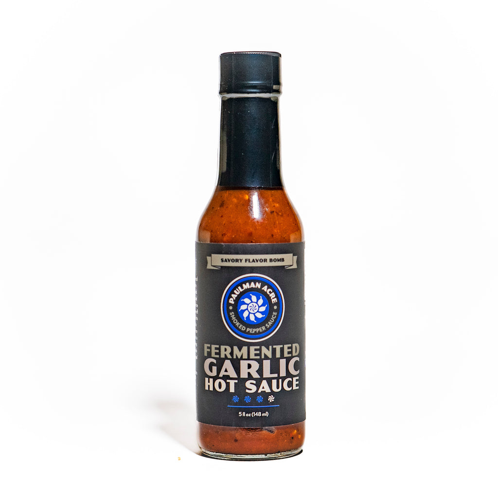 Bottle of fermented garlic hot sauce on a white background